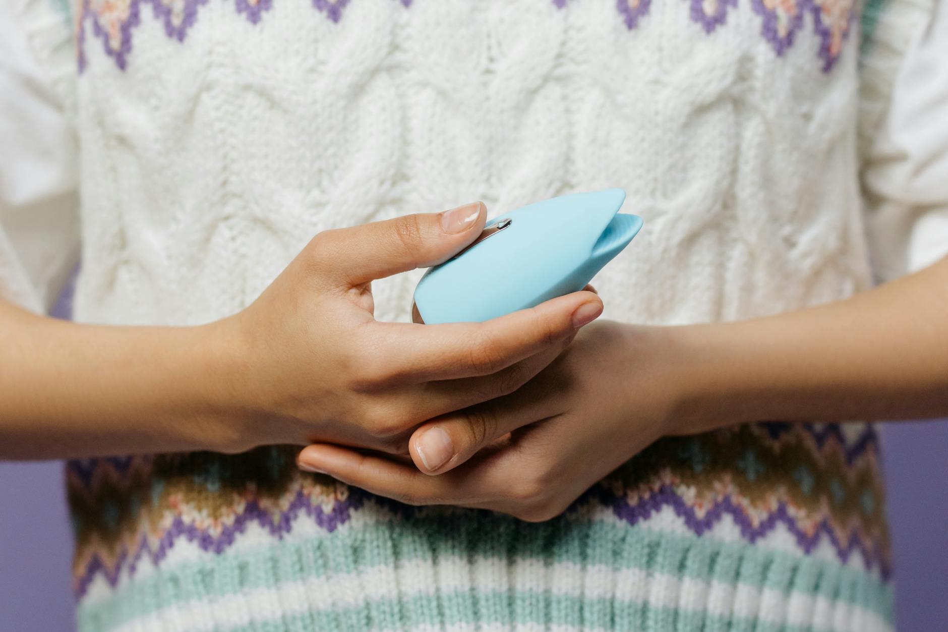 Hands holding a blue personal massager, demonstrating gentle grip and comfort