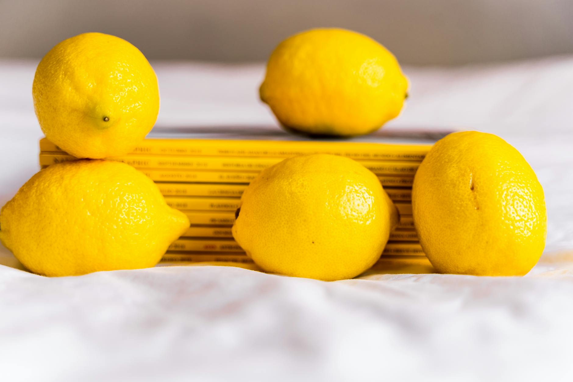 Fresh lemons with books on white surface, representing the transition and renewal of pleasure after menopause